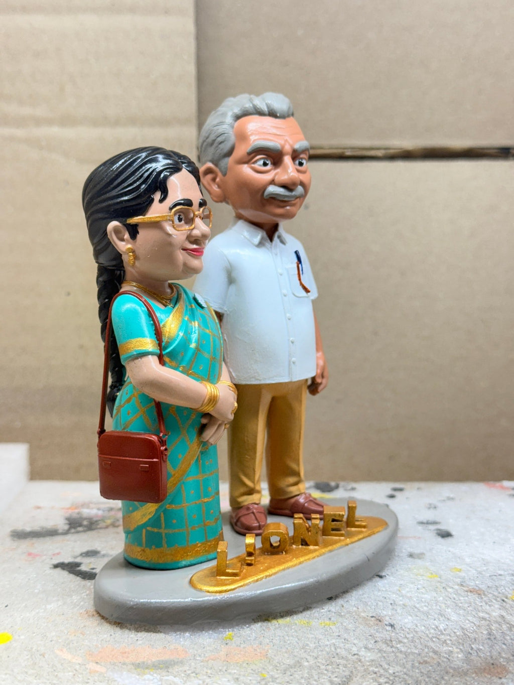 Side view of the parents' couple figurine with handbag and shirt-pocket pen details