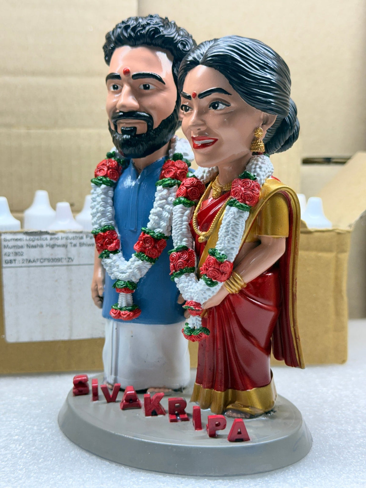Close-up of the wedding figurine showing hand-painted garlands and gold jewellery