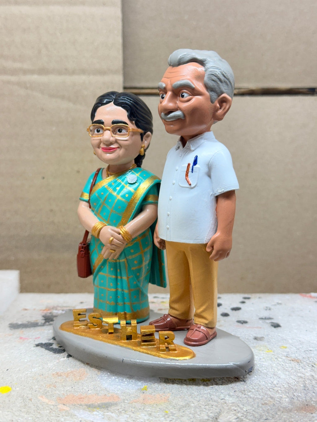 Custom couple figurine of parents in teal saree and white shirt, front view