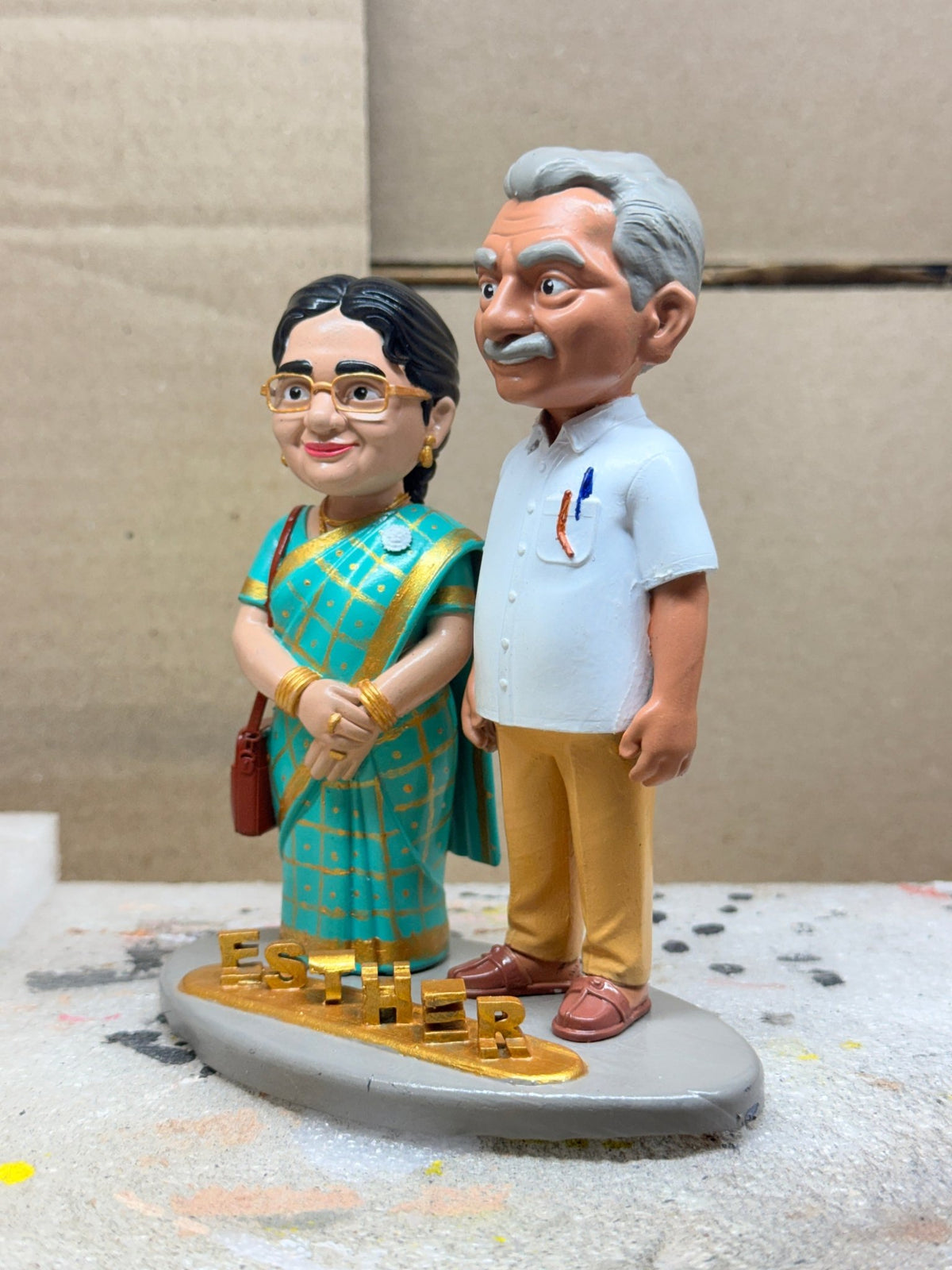 Custom couple figurine of parents in teal saree and white shirt, front view